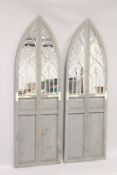 A PAIR OF TALL STANDING GOTHIC DOORS with mirrored panels. 6ft high x 1ft 10ins wide.