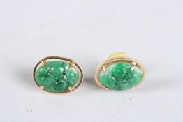 A PAIR OF GOLD AND CARVED JADE OVAL EARRINGS.