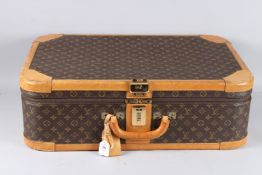 LOUIS VUITTON. A contemporary suitcase, monogrammed covering with leather edges and corners,