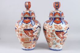 A VERY GOOD PAIR OF OCTAGONAL IMARI VASES AND COVERS. 20ins high.