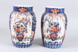 A SMALL PAIR OF RIBBED IMARI VASES. 10ins high.