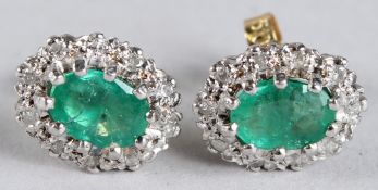 A PAIR OF 18CT GOLD, EMERALD AND DIAMOND CLUSTER EARRINGS.