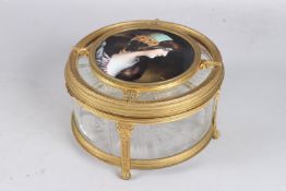 A SUPERB LIMOGES GLASS AND GILT METAL CIRCULAR BOX AND COVER, the lid with an enamel circular plaque