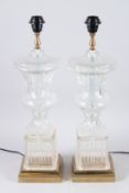 A PAIR OF GLASS URN SHAPED LAMPS on square bases.