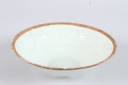 A CHINESE CIRCULAR POTTERY BOWL with decoration in relief. 7.5ins diameter.