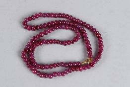 A RUBY BEAD NECKLACE with gold clasp. 18ins long.