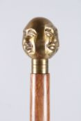 A WALKING STICK with a four-faced Buddha.