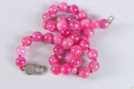 A GOOD SIX ROW PINK JADE NECKLACE with gold and diamond clasp.