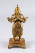 A SMALL GILT BRONZE FIGURE OF A STANDING CHINESE DEITY. 9ins high.