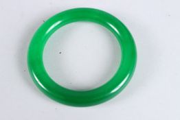 A CHINESE APPLE GREEN JADE BANGLE. 3ins diameter.