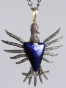 A LARGE BIRD PENDANT SET WITH RUBY EYE AND DIAMONDS, with a navy blue enamel inlay, in white and