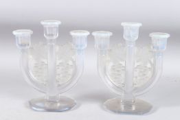 A PAIR OF BLUE TINTED THREE BRANCH CANDLESTICKS decorated with fruiting vines. 8.5ins high.