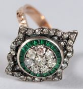 AN UNHALLMARKED ROSE GOLD QUATREFOIL STYLE RING SET WITH CALIBRE CUT EMERALDS AND RBC DIAMONDS