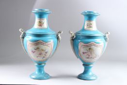 A PAIR OF SEVRES STYLE PORCELAIN TWIN HANDLED PEDESTAL VASES, blue ground, decorated with panels