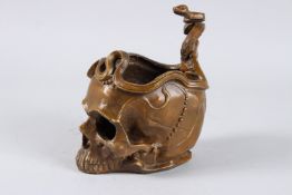 A BRONZE SKULL with a snake. 7ins high.