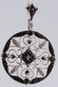 A CIRCULAR OPENWORK SILVER PENDANT set with black and white cubic zirconia on a silver chain.