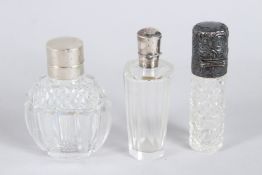 THREE SILVER TOPPED SCENT BOTTLES.