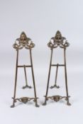 A SMALL PAIR OF BRONZE EASELS. 22ins high.