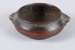 A CHINESE BRONZE CIRCULAR CENSER with foo dog handles. Impressed mark. 4.5ins high.
