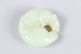 A CHINESE WHITE JADE CARVING depicting a mythical creature intertwined with foliage or waves. 5cms