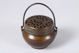 A SMALL CHINESE BRONZE CIRCULAR CENSER with handle. 2.25ins.