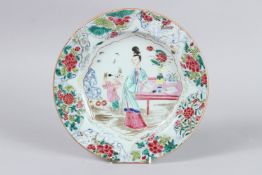 A CHINESE FAMILLE ROSE PLATE with floral border and two figures beside a table. 8.5ins diameter.