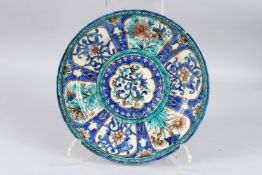 A FINE 19TH CENTURY PERSIAN QAJAR GLAZED POTTERY DISH with floral decoration. 11ins diameter.