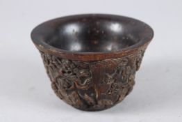 A CHINESE CARVED HORN CIRCULAR BOWL, carved with trees. 4.75ins diameter.