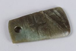A CHINESE JADE PENDANT OR AMULET carved with intricate patterns of swirling motifs. 10cms long x 4.