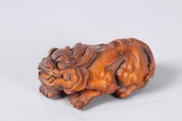 A CARVED WOOD FOO DOG. 3ins.