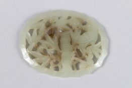 A CHINESE JADE OVAL PIERCED PENDANT depicting elements of flora, like bamboo. 6cms long x 4.5cms