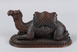 A VERY GOOD CARVED WOOD CAMEL on a rectangular base, 10ins long x 5ins high. POSSIBLY BLACK FOREST