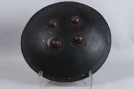 AN 18TH CENTURY INDIAN LEATHER SHIELD. 16ins diameter.