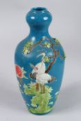 A CHINESE BLUE GROUND VASE with pelicans in relief. Impressed mark. 9ins high.