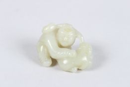 A CHINESE HETIAN JADE CARVING of a small boy. 5cms long x 2.5cms wide. 77grams.