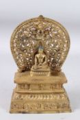 A CHINESE GILT BRONZE SEATED DEITY with halo, on a stepped base. 10.5ins high.