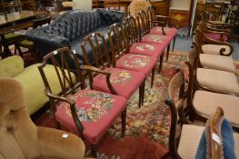 A set of six mahogany dining chairs, two with arms all with needlework upholstered seats.