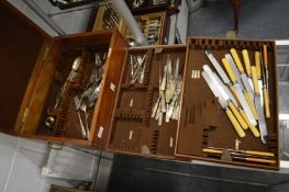 An oak cutlery canteen containing various flatware.