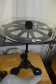 An unusual glass, wood and cast iron wagon wheel table.