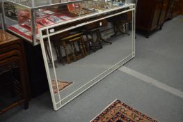 A large modern white framed rectangular mirror.