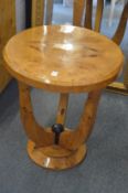 An Art Deco style circular blonde wood occasional table.