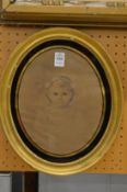 Bust length portrait of a young girl, possibly over a print base, in an oval verre eglomise frame.