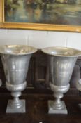 A pair of aluminium pedestal urns.