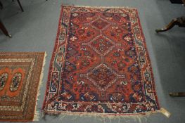 A small Persian design rug, red ground with stylised decoration, 148cm x 107cm.