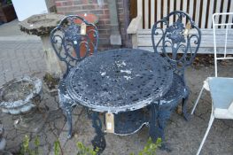 A black painted aluminum circular patio table and pair of chairs.