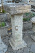 A reconstituted stone rustic style bird bath.