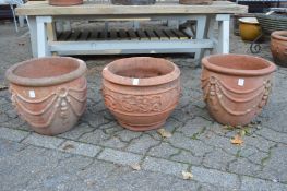 A pair of classical style terracotta plant pots and similar plant pot.