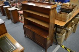 A mahogany open bookshelf with a pair of cupboard doors below.