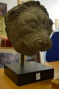 An early Indian sandstone sculpture depicting a lions head mounted on a stand.