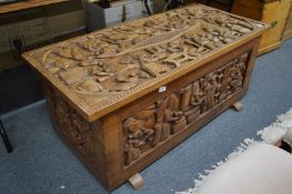 A hardwood coffer carved with figures.